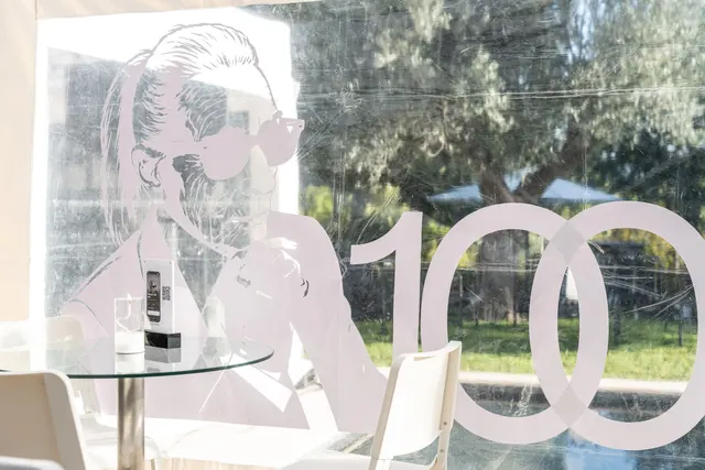 Décor de la fête : un grand « 100 » et la silhouette de Mémé avec ses lunettes de soleil, en noir et blanc