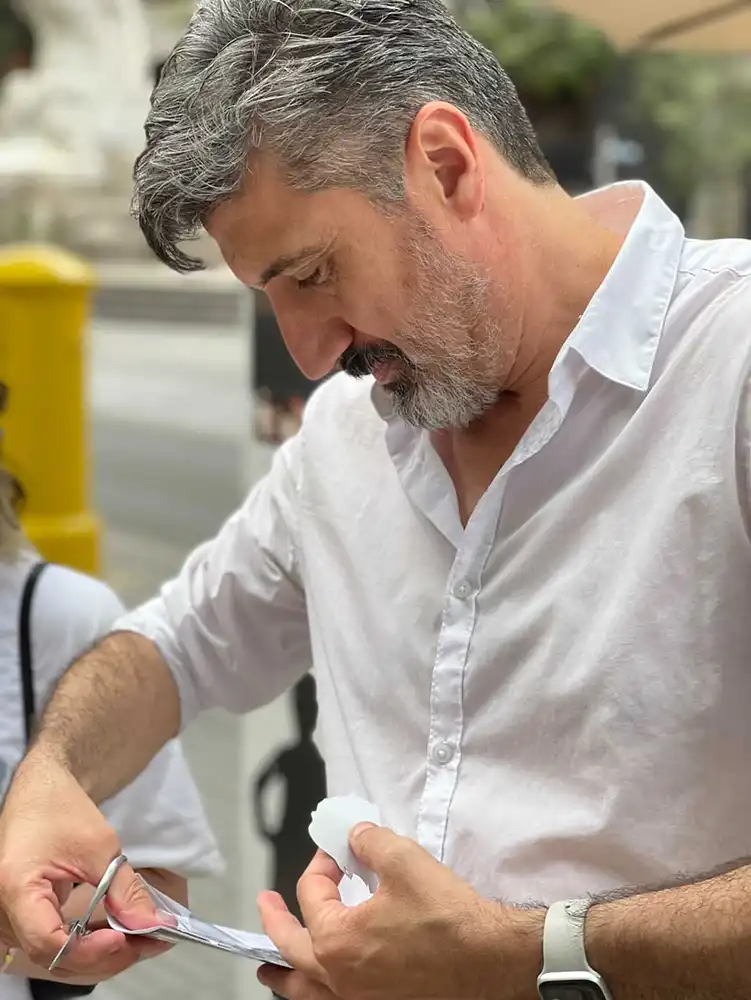Igor Kucinic découpant un portrait silhouette dans une feuille de papier pliée