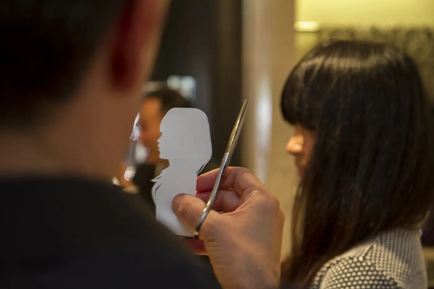Igor Kucinic découpant en direct un portrait silhouette lors d'un événement Dior