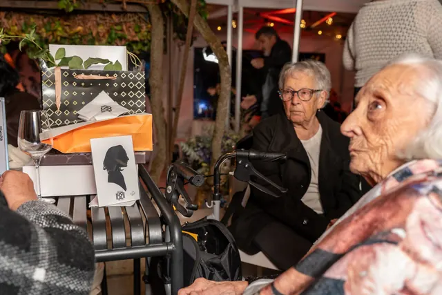 Mémé à table, entourée des siens, à côté de sa silhouette découpée à la main