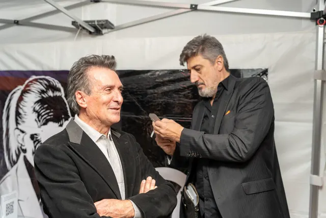 Igor Kucinic, silhouettiste, découpe aux ciseaux le portrait de profil d'un invité sous le chapiteau de la fête des 100 ans
